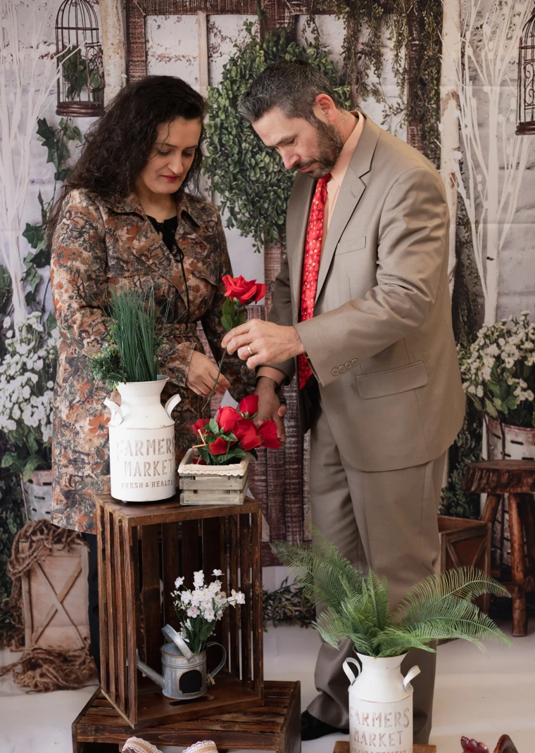 Casal organizando arranjo floral em ensaio na fazenda